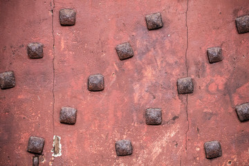 texture of antique square nails on old traditional red door