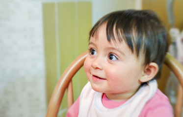 Happy baby girl seated looking on her right