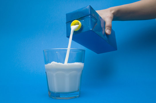 Hand Pouring Milk From A Carton Into A Glass