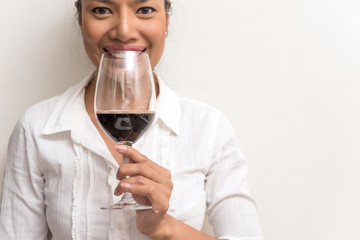 Beautiful business woman holding red wine glass for celebrate