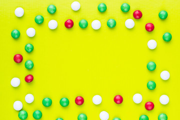 Candies in the shape of frame on yellow background