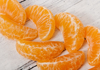 Tangerine slices on a wooden background, fruit.