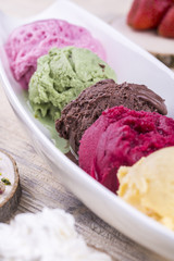 Balls of multi-colored ice cream in white glasswares 
