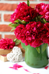 Bouquet of red peony flowers on a white wooden table