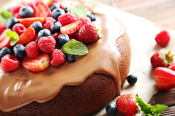 Homemade chocolate cake with berries on brown wooden table
