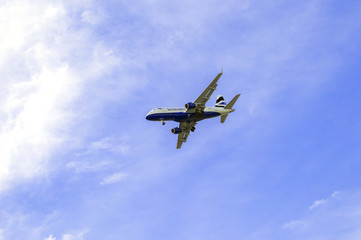 Fototapeta na wymiar Landing airplane and beautiful blue sky