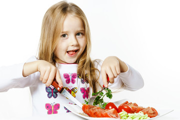 Cute little girl with plate of fresh vegetables