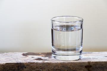 Drinking water in glass on a wooden floor.