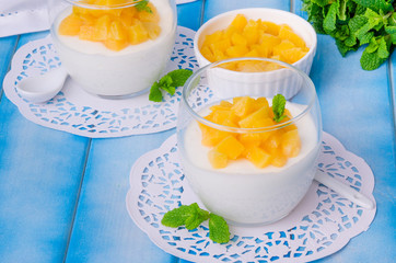 Bavarian cream mousse with vanilla and peaches in syrup in a glass
