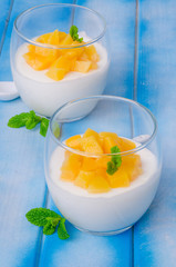 Bavarian cream mousse with vanilla and peaches in syrup in a glass