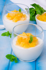 Bavarian cream mousse with vanilla and peaches in syrup in a glass