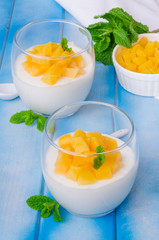 Bavarian cream mousse with vanilla and peaches in syrup in a glass