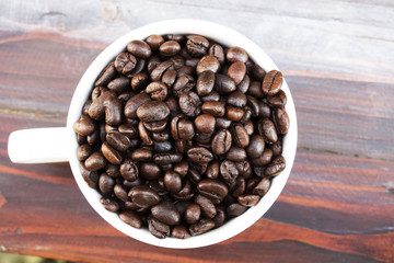 Coffee cup and coffee beans on wooden background. Top view.