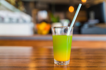 Fresh green and orange juice in a glass.