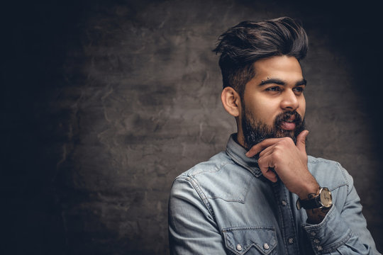 Handsome Indian male on grey background.