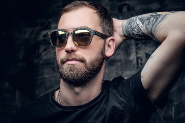 Fototapeta premium A man in sunglasses with tattoo on his arm.