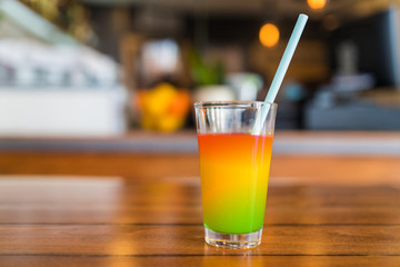 Fresh green and orange juice in a glass.