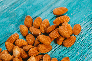 handful of almonds on a blue wooden background