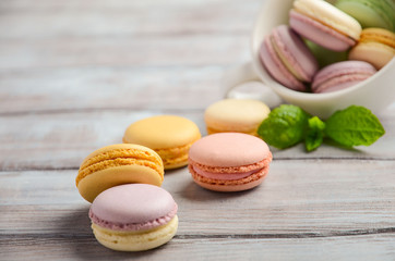 Colorful French macaroons on wooden background, selective focus, copy space