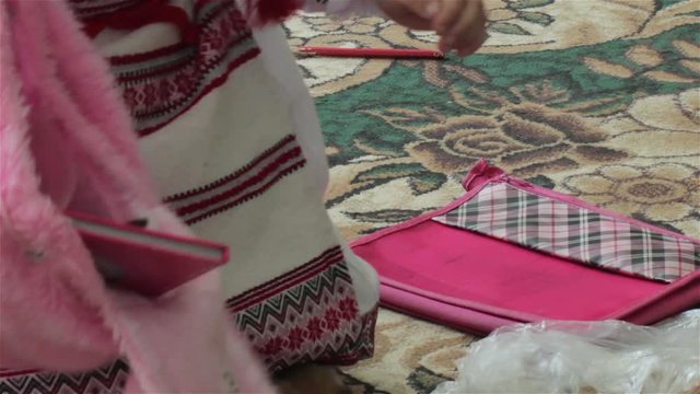 lay down books in the school bag/girl laid backpack in the middle of the book and pen