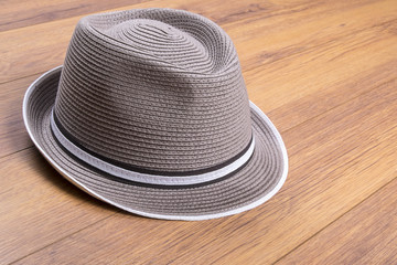 Fototapeta na wymiar Men's Stylish Straw Hat on Wood Flooring