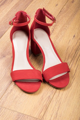 Women's Red Suede Sandals on Wood Flooring