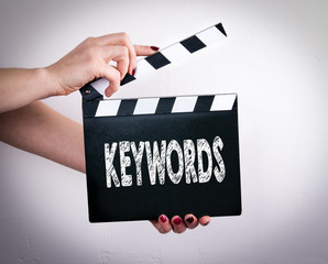 Keywords. Female hands holding movie clapper. Gray background   