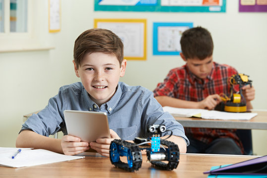 Pupil Controlling Robot With Digital Tablet In Science Lesson