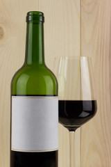 bottle of red wine with a brilliant glass on a