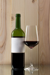 bottle of red wine with a brilliant glass on a glass stand