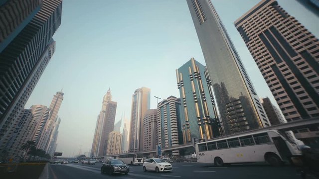 Skyscrapers with stained-glass facades in the UAE. Stone jungle: modern architecture and high buildings in Dubai. Busy vehicular traffic. The modern and developed metropolis. Urban.