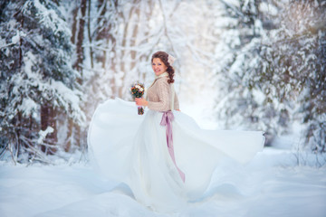 Fototapeta na wymiar Beautiful bride in snowy winter forest