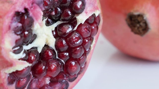 Close-up of red healthy Punica granatum 4K 3840X2160 UHD tilting video - Raw seeds inside Lythraceae family pomegranate fruit half slow tilt 2160p UltraHD footage