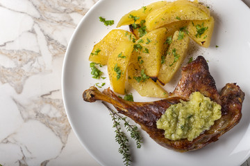 Roast duck with golden potatoes and garlic sauce with herbs on p