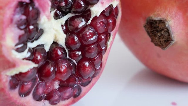 Raw seeds inside Lythraceae family pomegranate fruit half 4K 3840X2160 UHD tilting video - Red healthy Punica granatum close-up slow tilt 2160p UltraHD footage 