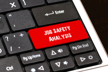 On the laptop keyboard the red button written Job Safety Analysi