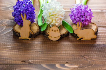 Beautiful Fresh hyacinth flowers and wooden rabbits and chicken on brown boards. Spring background for Easter. Free space
