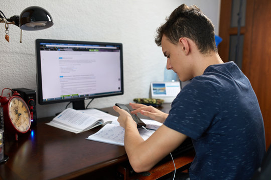Teenager doing homework with computer