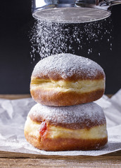 Fresh donuts with strawberry jam, sprinkled with powdered sugar