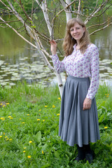 The young woman stands near the blossoming birch of useful (Hima