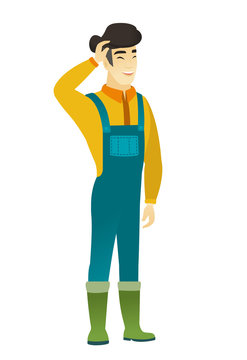 Young asian farmer in coveralls laughing.
