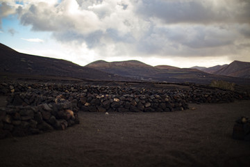 View of Volcanic Landscape with Black Rock Walls in Foreground 