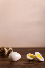 Quail eggs. Raw and boiled sliced food. Natural organic eco eggs. Wooden rustic background.