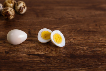 Quail eggs. Raw and boiled sliced food. Natural organic eco eggs. Wooden rustic background.