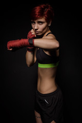 Fototapeta na wymiar Boxing woman with red boxing wraps on black background