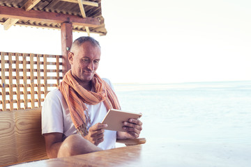 Smiling man with tablet relax on the seaside