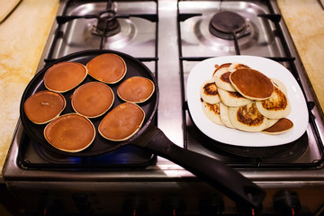 Making pancakes in a black pan. Shrovetide, pancake week
