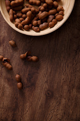 Sweet tamarind on grunge rustic wood background. Natural organic diet food with a lot of vitamins. Plate dish or bowl on wooden board.