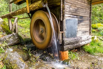 Papier Peint photo autocollant Moulins Hölzernes Wasserrad an einer kleinen Wassermühle