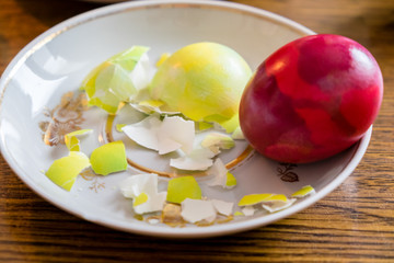 Painted Easter Eggs on a tray, one of them is broken eggshell